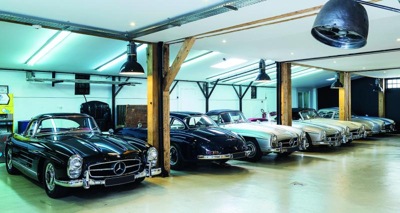 Nicolas Jambon Bruguier dans la cour de son atelier, assis dans la 300 SL ex-Moss.