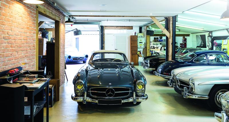 Nicolas Jambon Bruguier dans la cour de son atelier, assis dans la 300 SL ex-Moss.